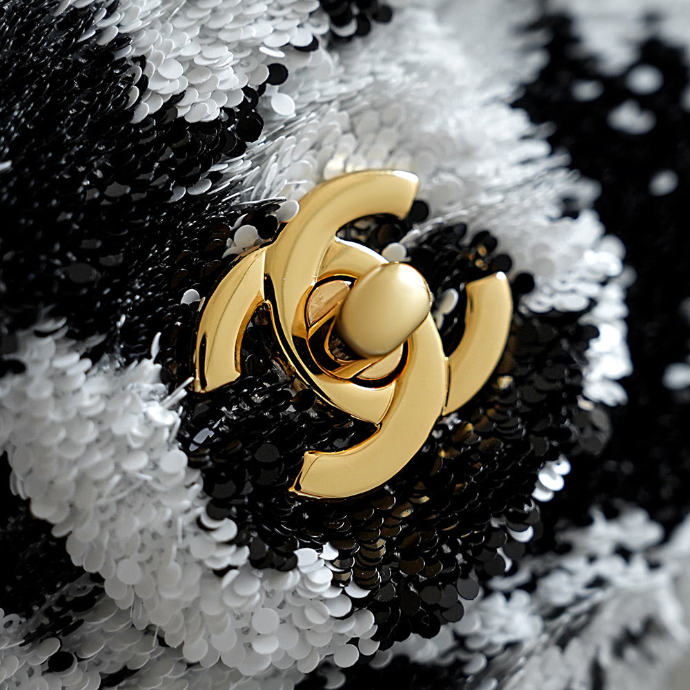 Gold Chanel CC logo on dark-and-white sequined fabric, round clasp