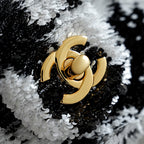 Gold Chanel CC logo on dark-and-white sequined fabric, round clasp