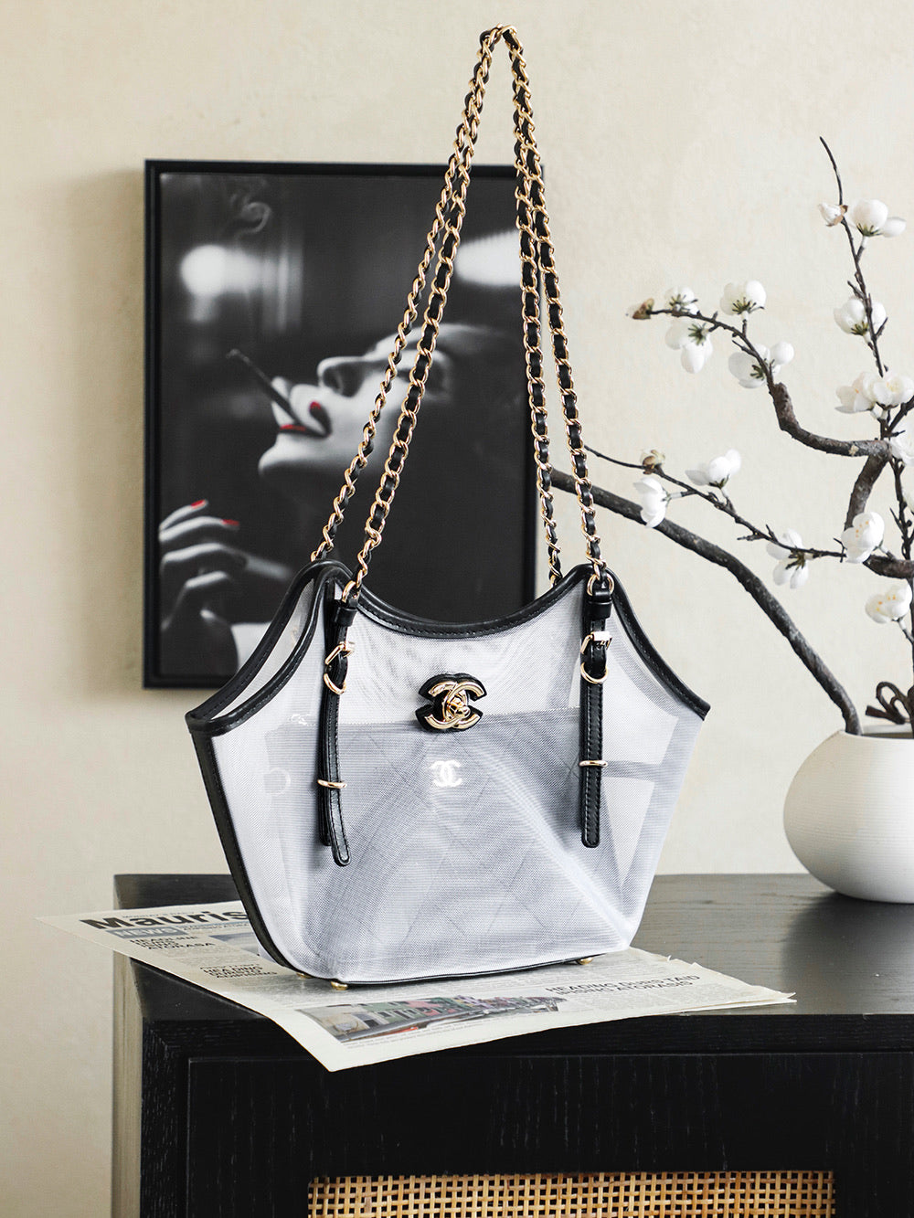 White and black Chanel tote bag with gold chain shoulder straps and CC emblem