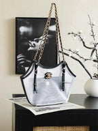 White and black Chanel tote bag with gold chain shoulder straps and CC emblem