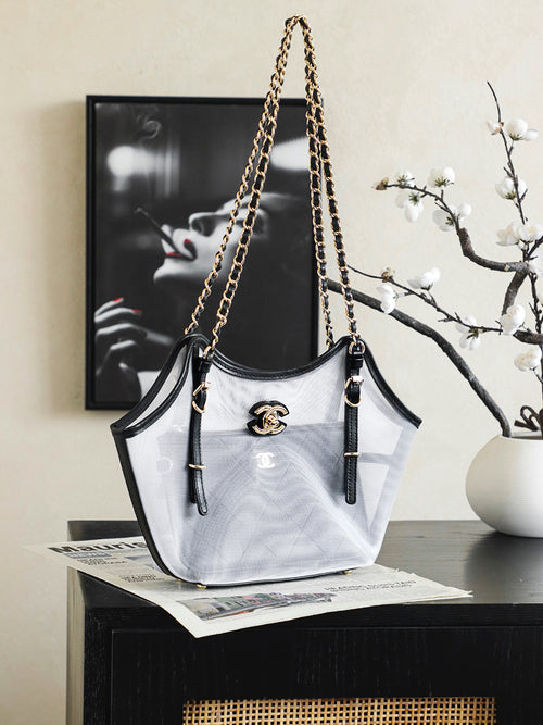 White and black Chanel tote bag with gold chain shoulder straps and CC emblem