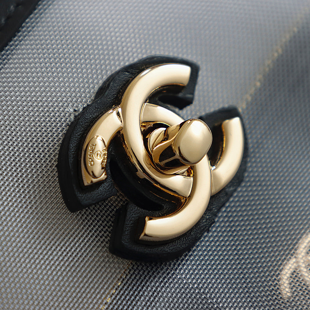 Gold-tone Chanel clasp hardware on black leather strap, close-up detail