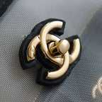 Gold-tone Chanel clasp hardware on black leather strap, close-up detail