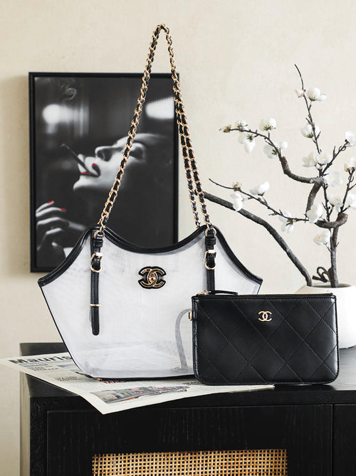 Two-tone Chanel tote bag with gold chain handles, black trim, and CC logo