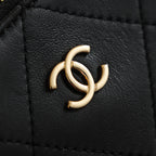 Chanel CC logo hardware on black leather bag panel, close-up