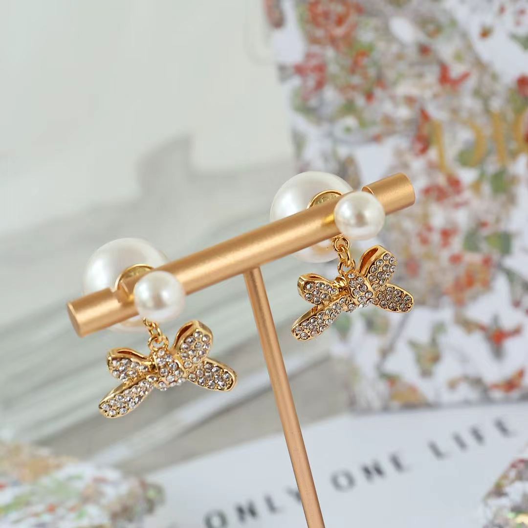 Gold-tone bar earrings with bow charms and pearl beads, crystal accents