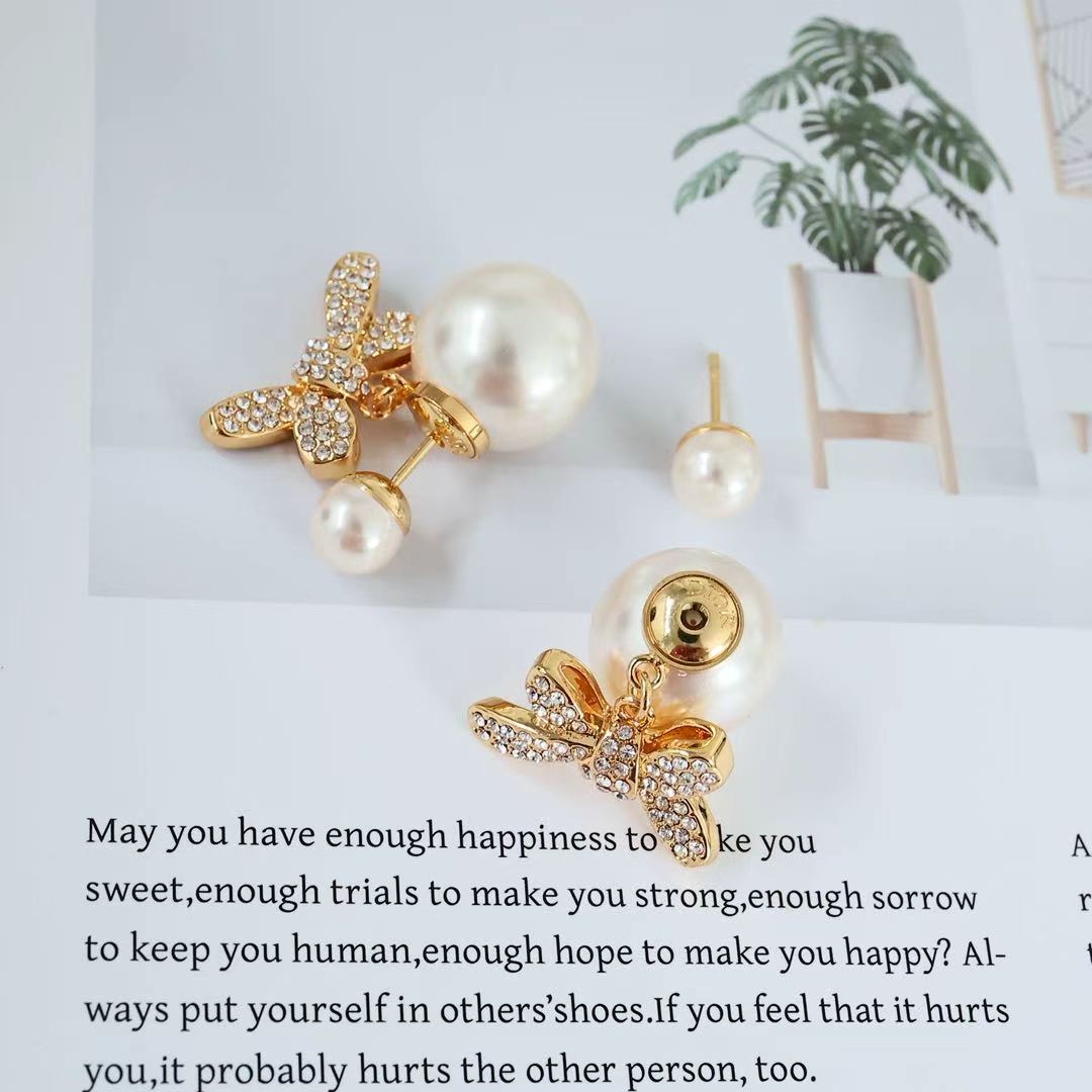 Gold-tone bow earrings with clear crystal accents and pearl drop