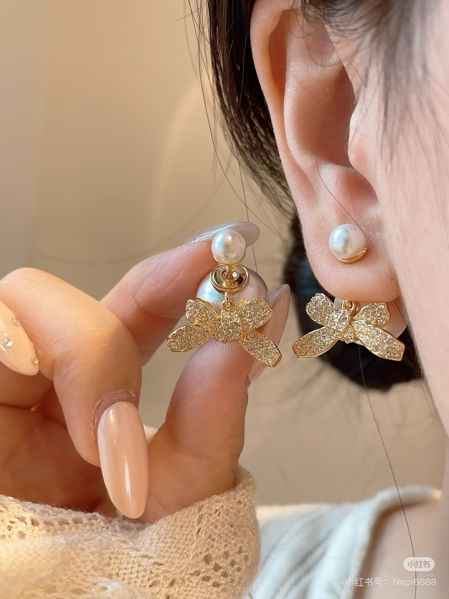 Floral bow earrings on model with pearl drops and gold-tone crystal details