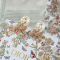 Dior floral bow earrings with gold-tone filigree, crystal detailing, and pearl drops