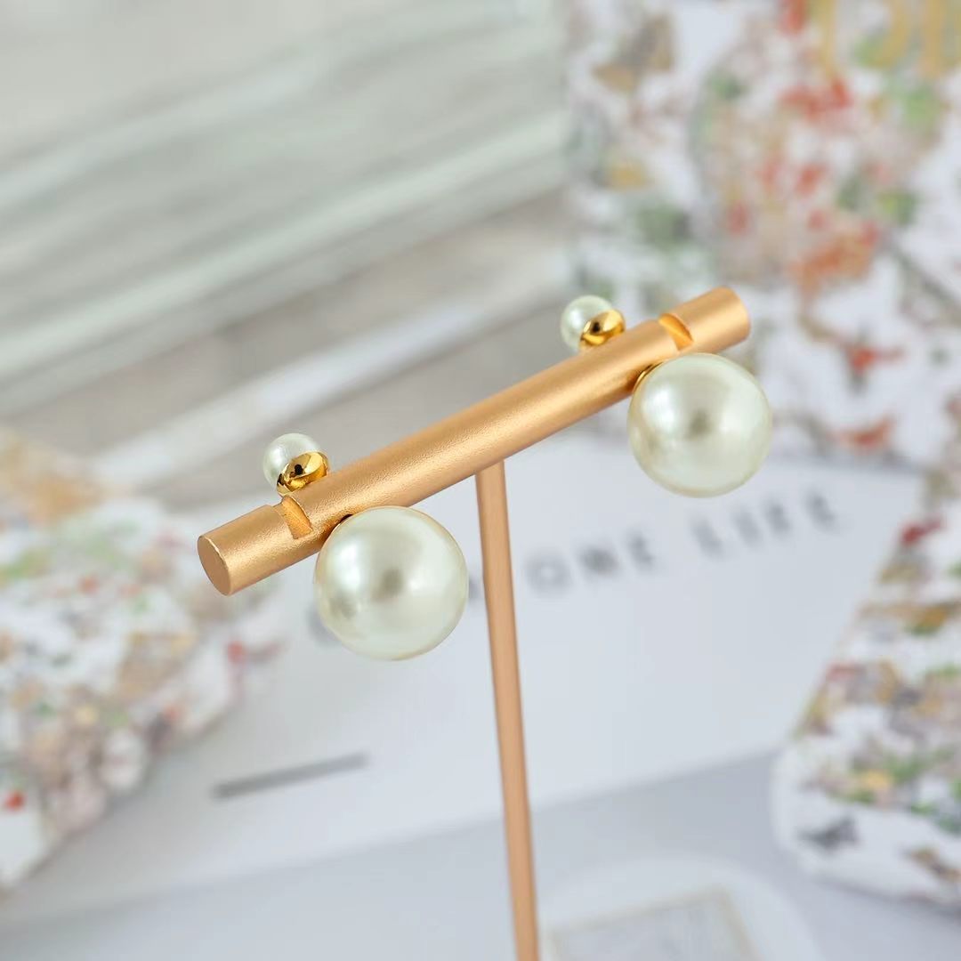 Gold-tone bar-style pearl drop earrings with three pearls and hook backings.