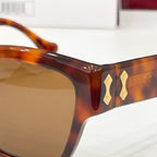 Gucci sunglasses close-up: tortoiseshell temple with gold-tone logo detail