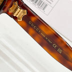 Gucci sunglasses close-up: tortoiseshell temple with gold emblem and text
