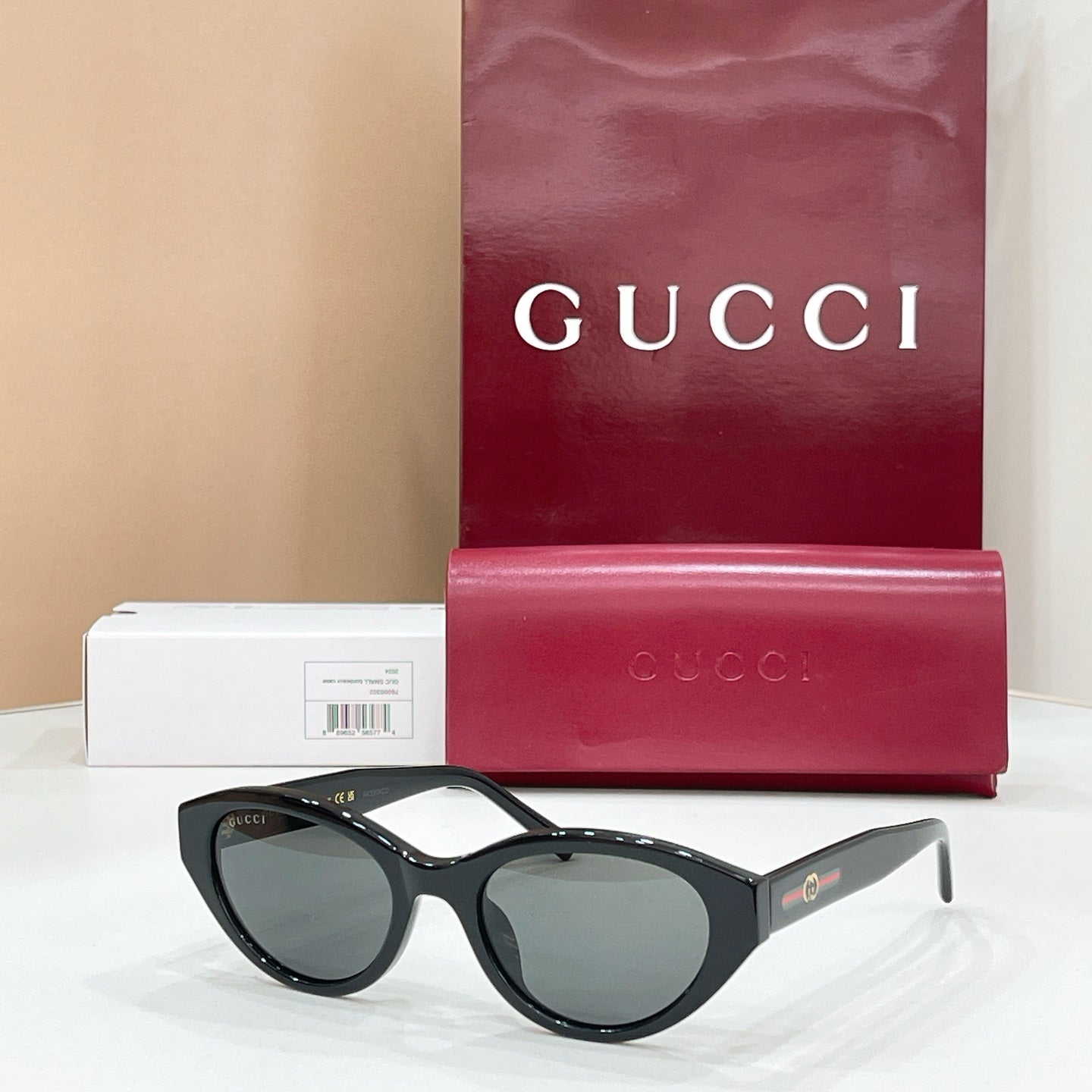 Black sunglasses with dark lenses, Gucci logo on temples and gold-tone detail.