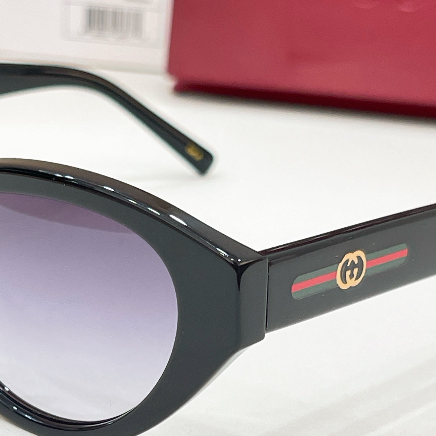 Black sunglasses temple with gold Gucci logo and multicolor stripe detail.
