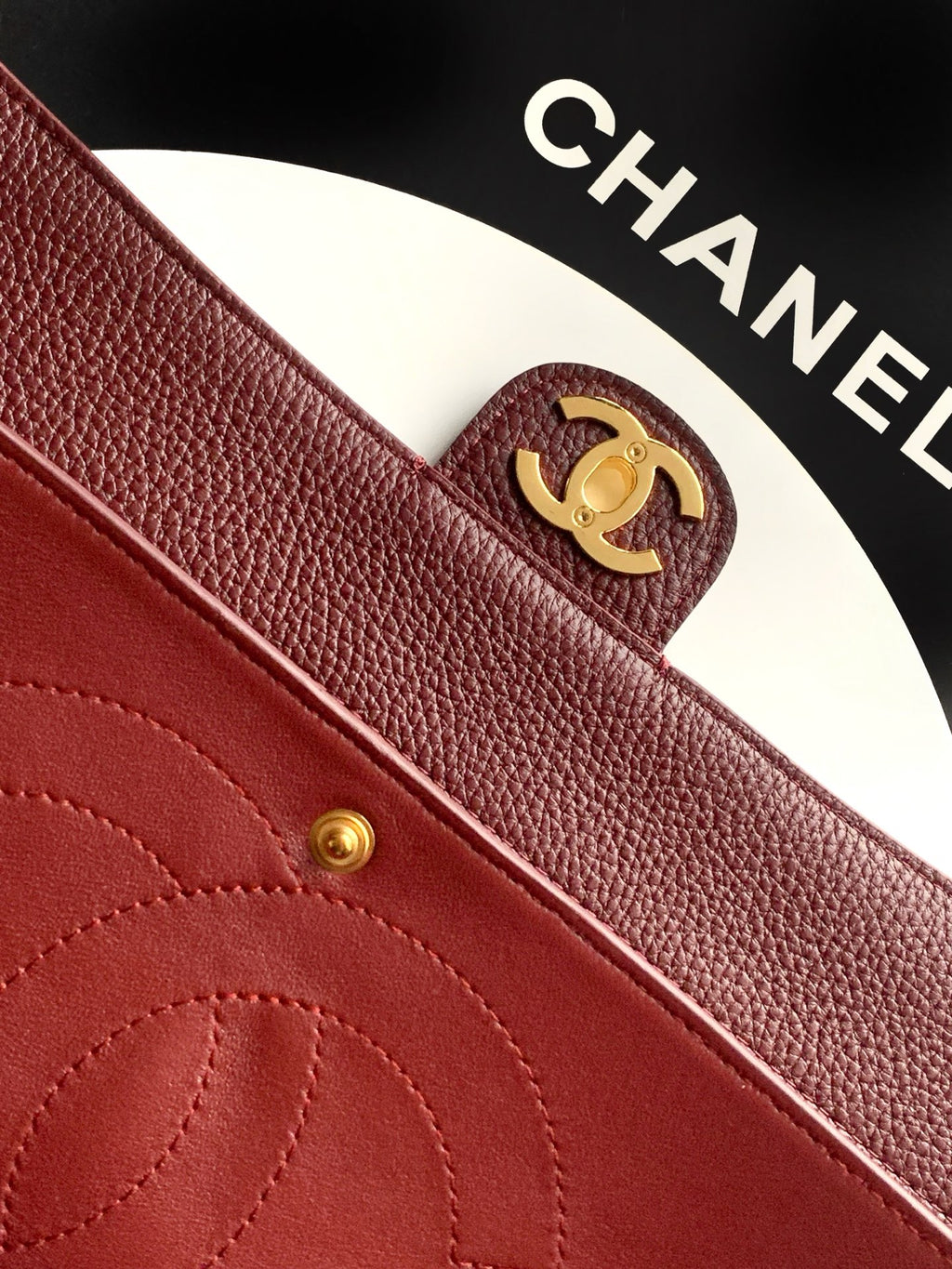 Chanel CC emblem on burgundy textured leather with stitched pocket