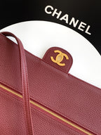Burgundy leather handbag with gold-tone zip and small Chanel CC badge