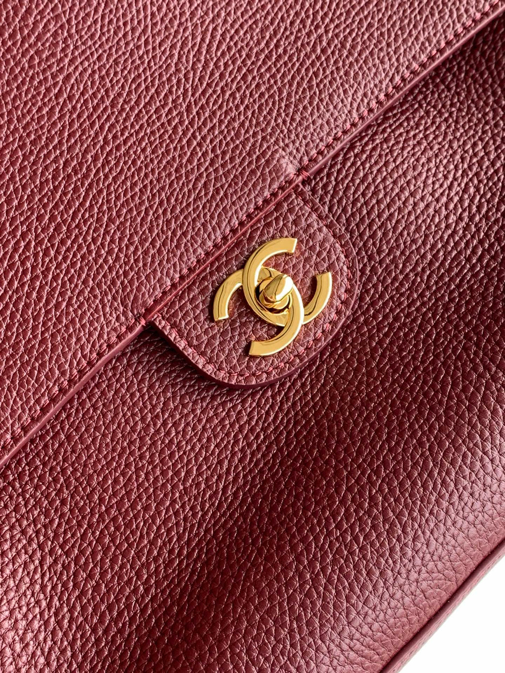 Burgundy textured leather flap bag with gold-tone Chanel CC emblem