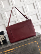 Burgundy leather flap shoulder bag with front pocket and gold-tone clasp