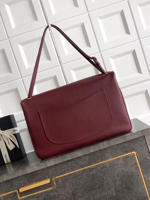 Burgundy leather flap shoulder bag with front pocket and gold-tone clasp