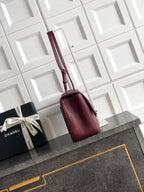 Burgundy Chanel small shoulder bag with short handles and structured shape.