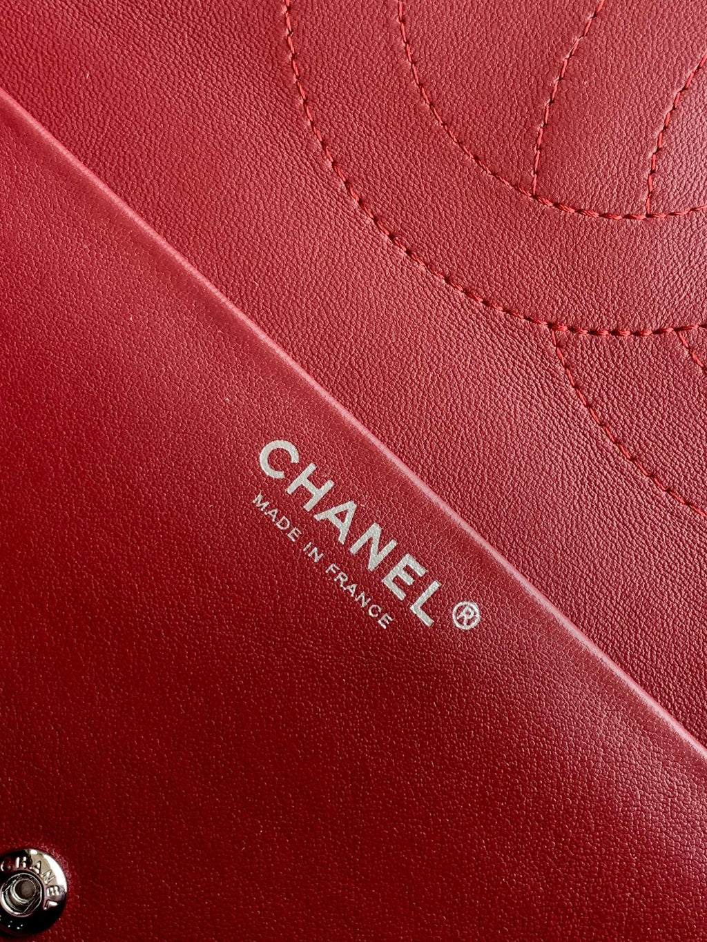 Burgundy Chanel bag with CHANEL and MADE IN FRANCE stamp on leather.