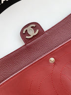 Burgundy Chanel bag with CC logo strap tab and stitched leather trim.