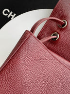 Burgundy Chanel bag with textured leather and gold-tone O-ring strap hardware.