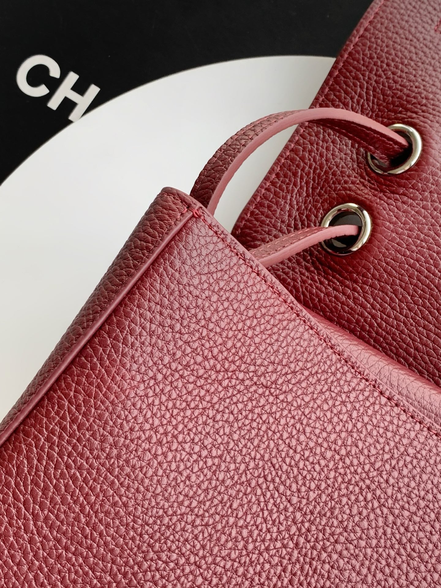 Burgundy Chanel bag with textured leather and gold-tone O-ring strap hardware.