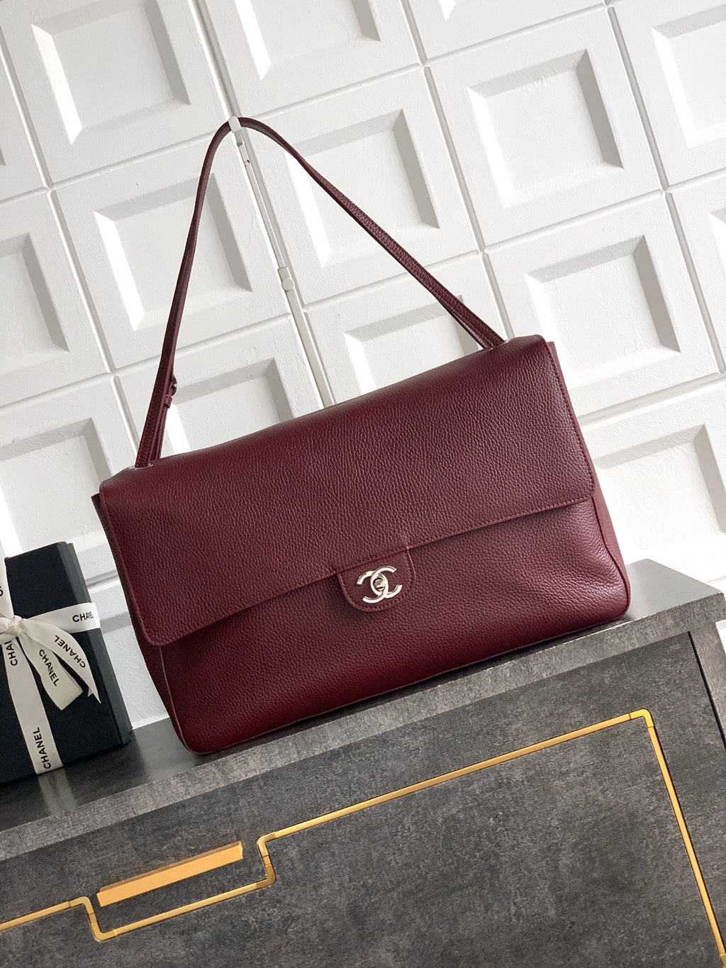 Chanel bag in textured maroon leather with flap and silver-tone logo on front