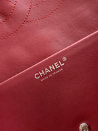 Chanel bag leather close-up in maroon with CHANEL® label and stitching detail