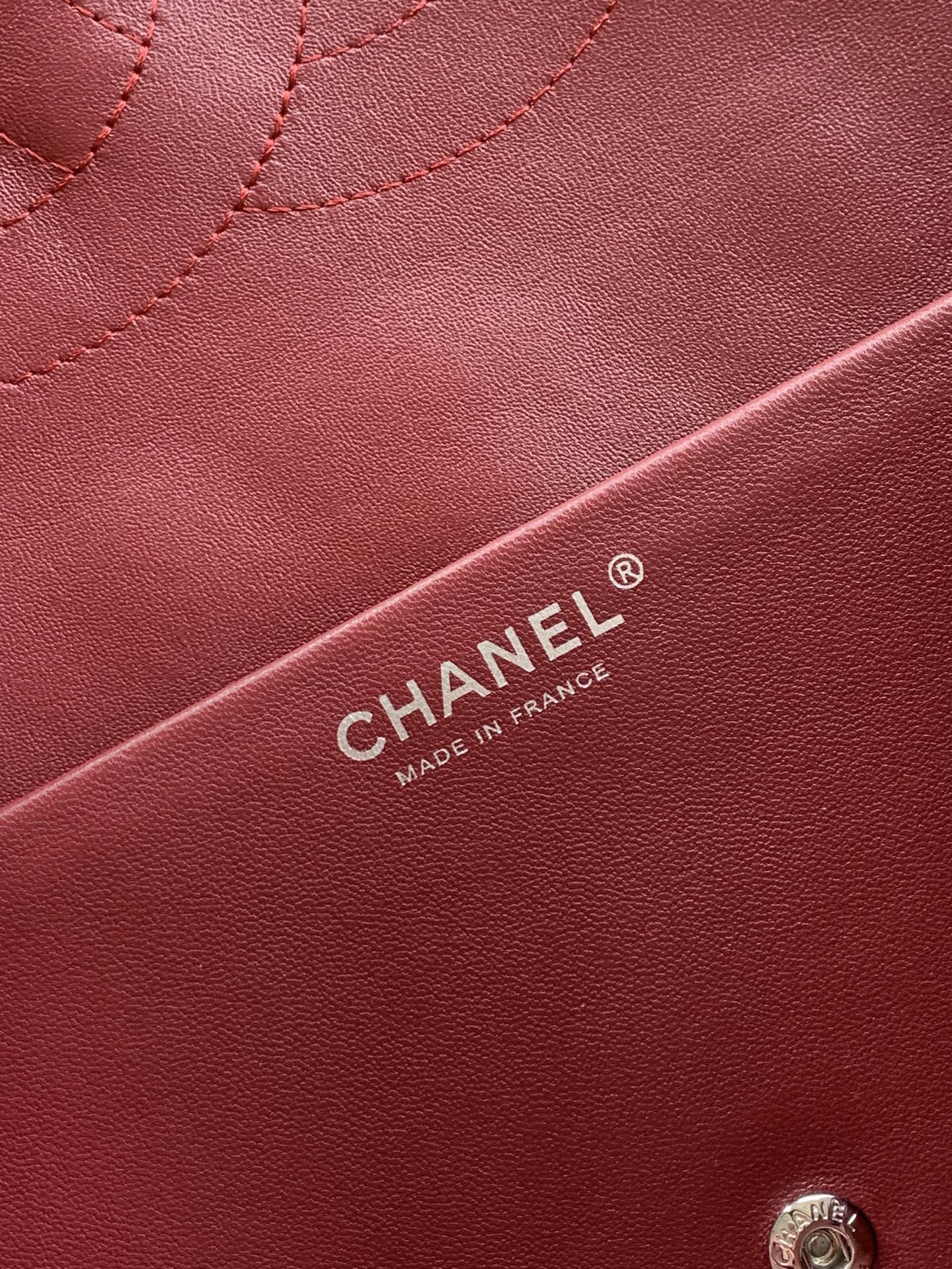 Chanel bag leather close-up in maroon with CHANEL® label and stitching detail