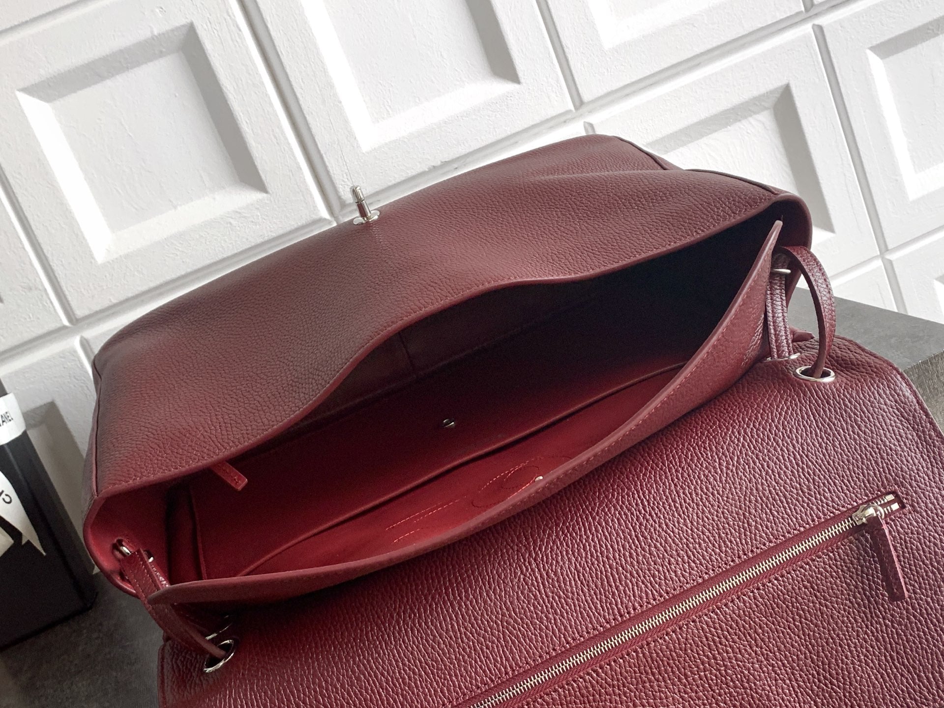 Chanel bag open view in textured maroon leather with zipper top and interior lining