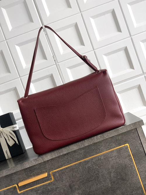 Chanel shoulder bag in textured maroon leather with front flap and logo turn-lock