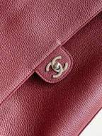 Chanel bag detail: maroon textured leather flap with silver-tone interlocking logo