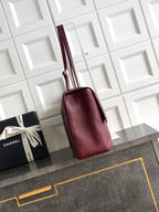 Chanel bag with tall silhouette in textured maroon leather, top strap and flap closure
