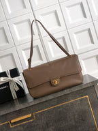 Chanel shoulder bag in taupe leather with gold logo clasp and flap front