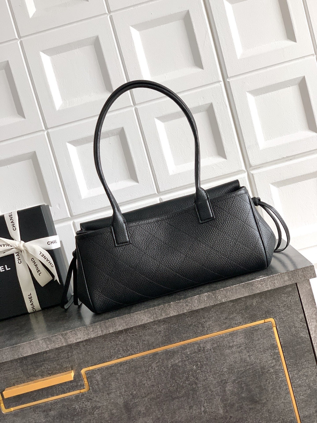 Black Chanel top-handle bag with gold logo and structured body