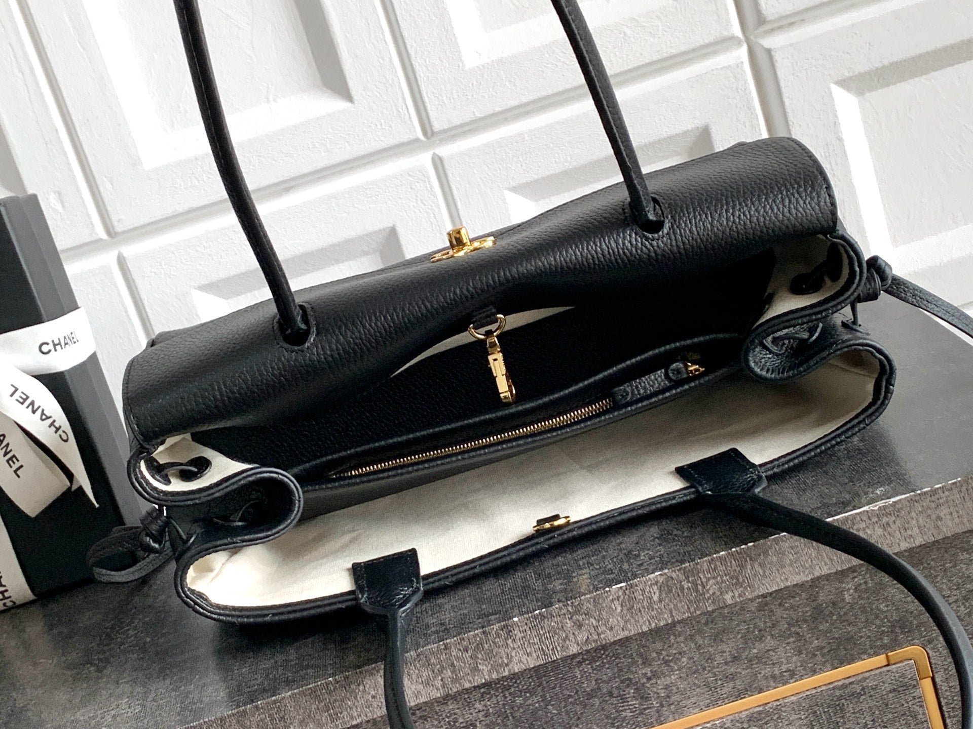 Black Chanel handbag open view with zip pocket and crossbody strap
