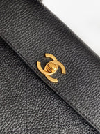 Black textured leather flap with gold Chanel turn-lock clasp