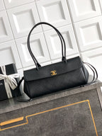 Black Chanel top-handle bag with gold logo plate on the front