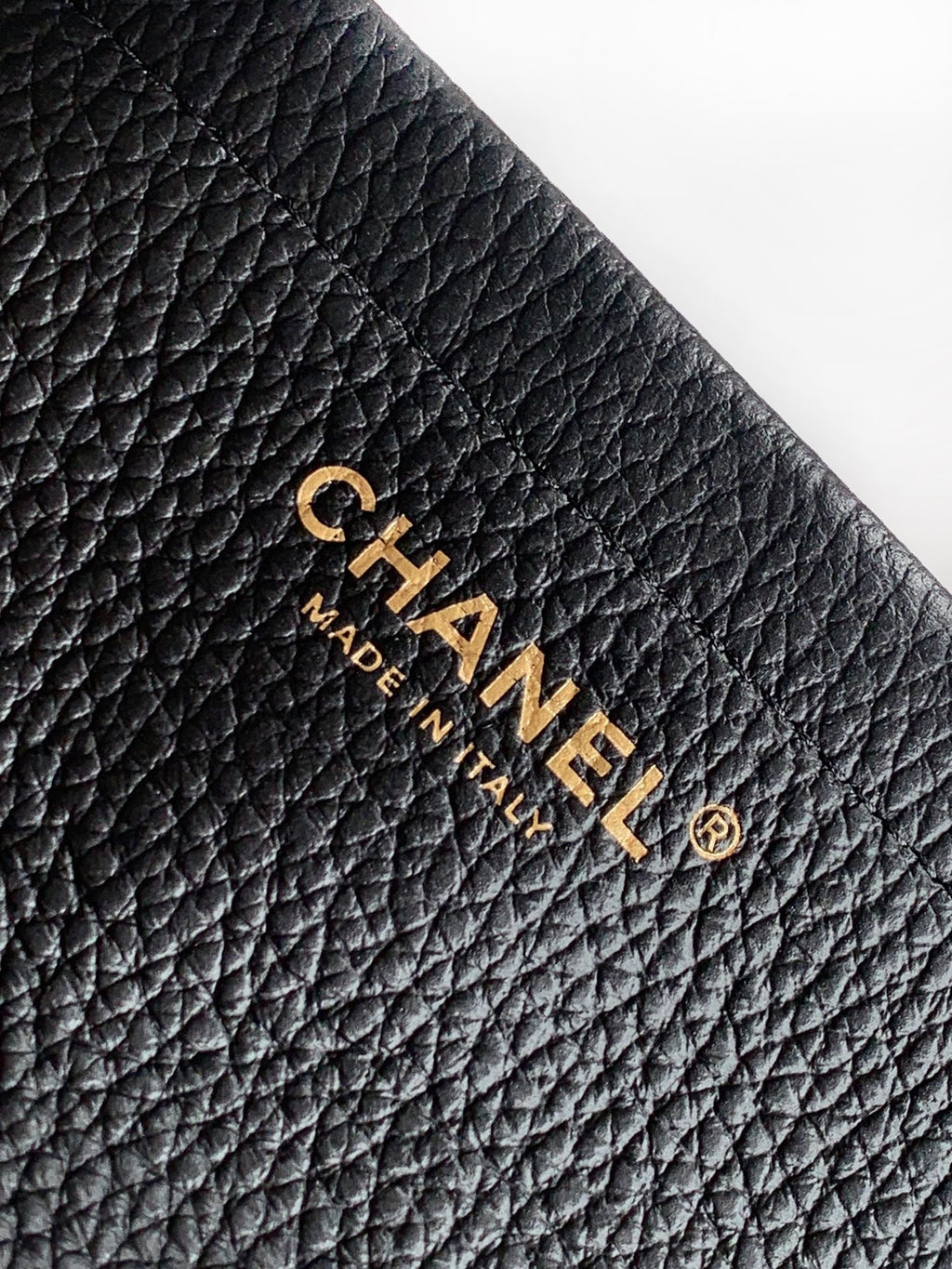 Black quilted Chanel leather bag with gold "CHANEL" and "MADE IN" mark