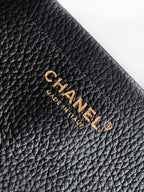 Black quilted Chanel leather bag with gold "CHANEL" and "MADE IN" mark