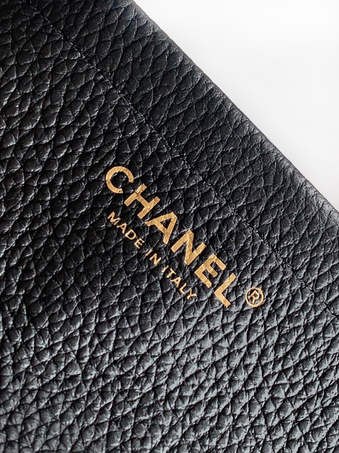 Black quilted Chanel leather bag with gold "CHANEL" and "MADE IN" mark