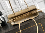 Beige Chanel leather handbag opened to show interior, top handles and adjustable strap