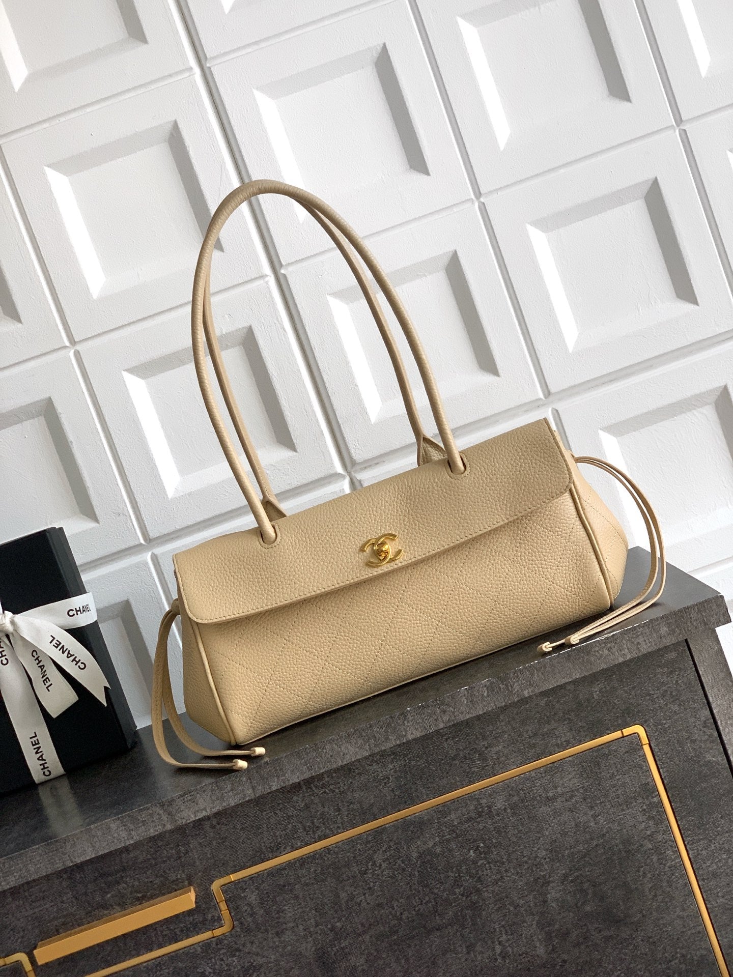Beige Chanel leather handbag with top handles, gold-tone clasp and shoulder strap