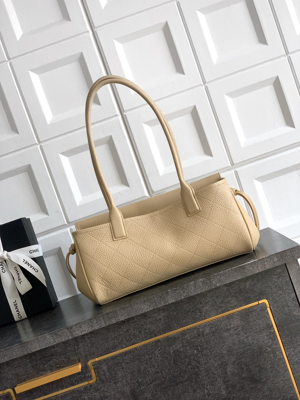 Beige Chanel leather handbag with top handles and front clasp, minimal gold hardware