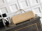 Beige Chanel leather handbag with shoulder strap and gold-tone clasp on tabletop