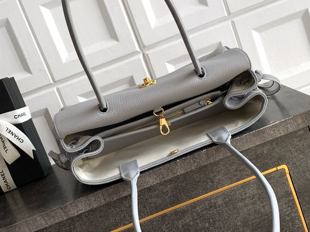 Chanel bag interior view in light gray leather with gold zipper hardware and straps