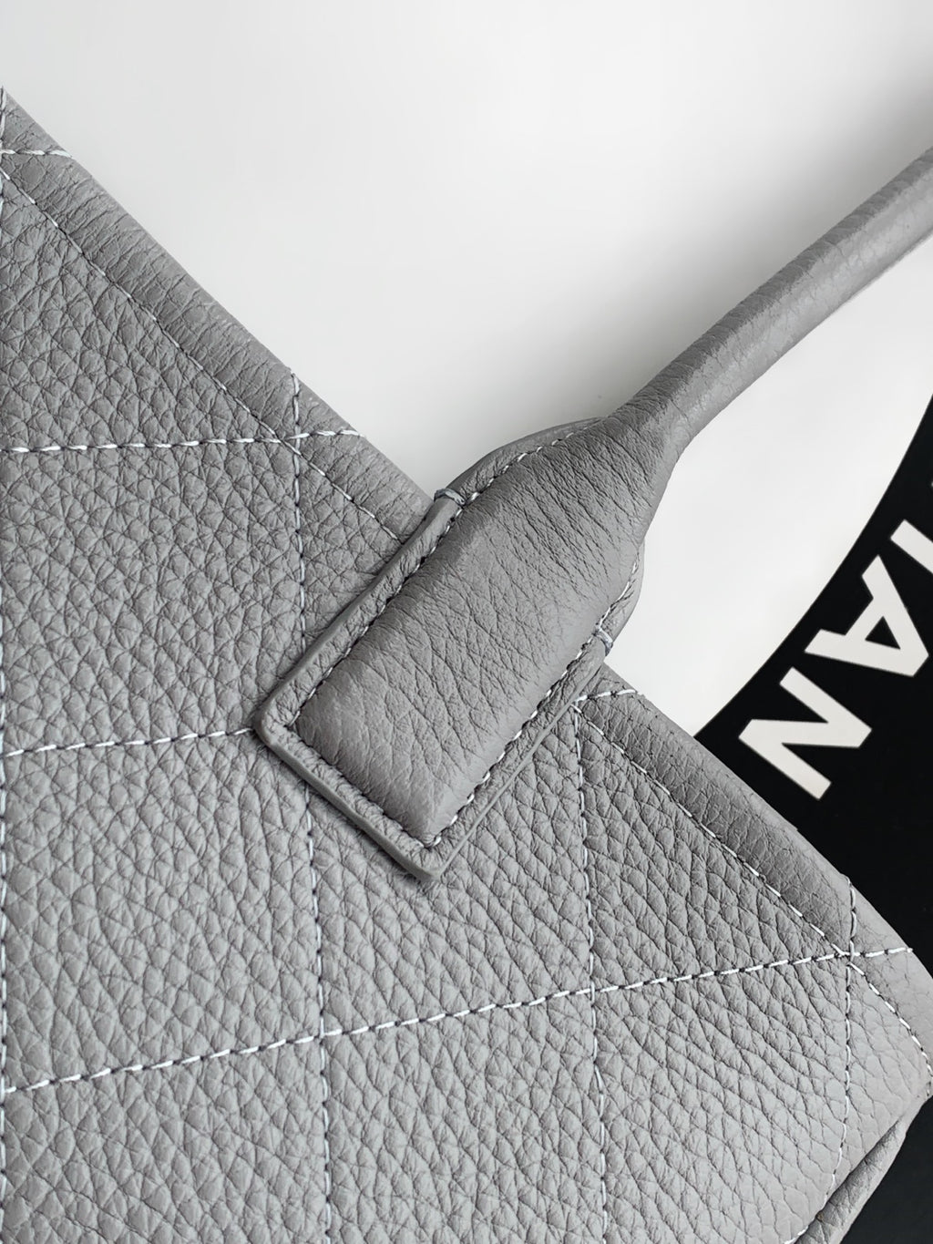 Chanel light gray leather bag corner with quilted stitching and metal frame detail