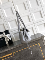 Chanel handbag in light gray leather with top handles and long shoulder strap